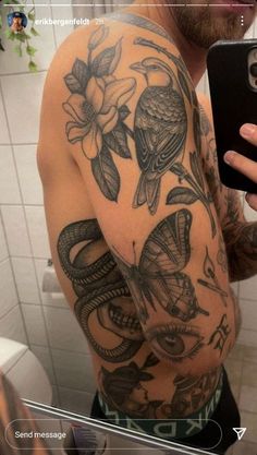 a man is taking a selfie in the mirror with his cell phone and tattoos on his arm