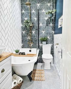 a white toilet sitting next to a bath tub in a bathroom under a wooden shelf