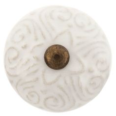 a white and gold knob with swirl designs on the front, set against a white background