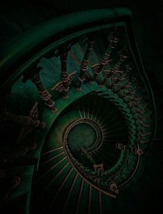 a spiral staircase in the dark with green lighting