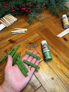 a person is making christmas decorations out of popsicle sticks and glue on the floor