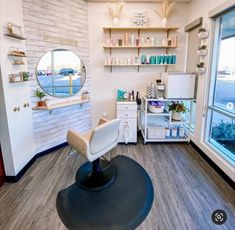 a salon room with a mirror, sink and hair dryer on the floor in front of a window