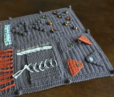 a crocheted table mat with buttons and other items on it, sitting on a wooden surface