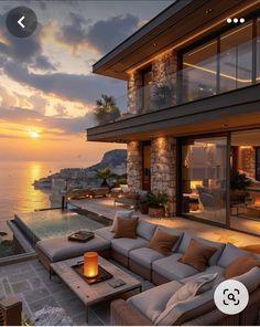 an outdoor living area overlooking the ocean at sunset