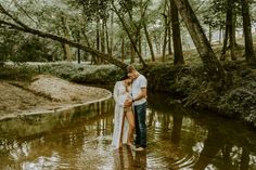 a man and woman standing in the middle of a river holding each other's hands