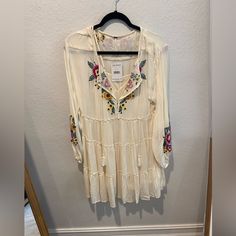 Beautiful White Free People Dress With Embroider Detail. Size Xs New With Tags Attached. Please Note Slight Damage To Interior Dress On The Fourth Picture. Spring Vacation Mini Dress With Floral Embroidery, Cream Mini Dress With Floral Embroidery For Spring, Cream Long Sleeve Mini Dress For Beach, Spring Vacation Mini Dress In Rayon, Spring Beige Boho Tunic Dress, Cream Long Sleeve Midi Beach Dress, Cream Long Sleeve Midi Dress For Beach, Spring Beach Boho Dress With Long Sleeves, Long Sleeve Cream Midi Dress For Beach