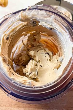 a bowl filled with peanut butter on top of a wooden table