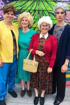 three women standing next to each other in front of a wall