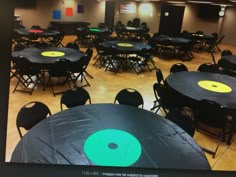 tables and chairs are set up in an empty room with green circles on the table