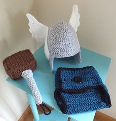 three crocheted hats sitting on top of a blue table next to each other