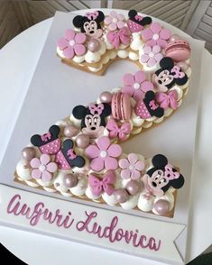 a cake shaped like the number one with minnie mouse decorations