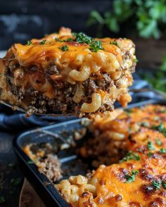 a piece of casserole with meat and cheese is being lifted from a baking dish