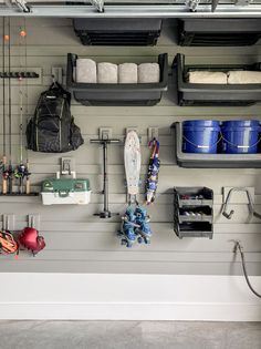 a garage with several storage bins and various items hanging on the wall above it