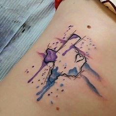 a watercolor tattoo on the back of a woman's thigh