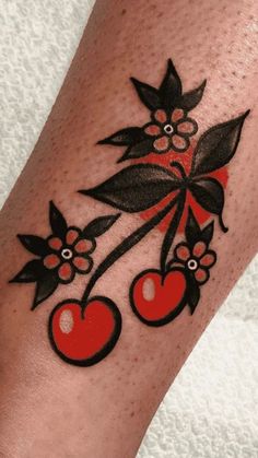 a tattoo with cherries and leaves on it