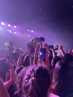 people taking pictures with their cell phones at a concert