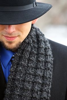 a man wearing a black hat and scarf