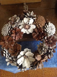 a wreath made out of pine cones and flowers