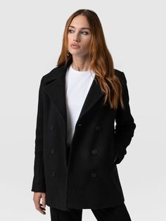 A timeless, statement pea coat in Black.  This semi-fitted coat, elegantly designed to hip length, embraces a flattering silhouette that complements any outfit.  Its long sleeves and back vent provide both comfort and mobility without sacrificing elegance.  Fully lined with a back neck chain and contrast red internal binding.  for luxury from the inside out.  Featuring six branded buttons and two internal jigger buttons, this coat boasts refined detailing that elevates its charm.  Embrace the al Modern Pea Coat With Hidden Button Closure, Modern Long Sleeve Pea Coat With Double-breasted Buttons, Modern Pea Coat For Work, Sleek Double-breasted Outerwear With Lapel Collar, Chic Business Pea Coat With Long Sleeves, Chic Long Sleeve Pea Coat For Business, Sleek Winter Outerwear With Button Closure, Sleek Double-breasted Winter Outerwear, Chic Business Peacoat