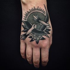 a person's hand with a bird tattoo on it