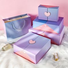 three boxes with hearts on them sitting on a furnishing area next to perfume bottles