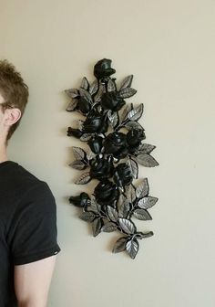 a man standing in front of a wall sculpture