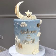 there is a blue and white cake with stars on the top that says welcome to the world