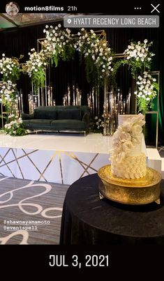 a wedding cake sitting on top of a table next to a black and white backdrop