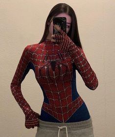 a woman is taking a selfie with her cell phone wearing a spiderman costume