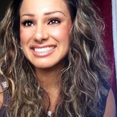 a woman with long hair smiling at the camera