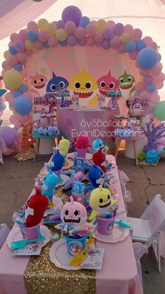 the table is set up with balloons and decorations