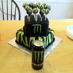 a birthday cake with monster energy on it and some lollipops in the middle