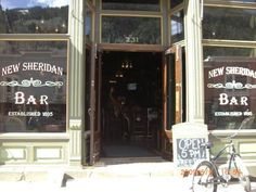 a bike is parked in front of the new sheridan bar, which has been opened for business