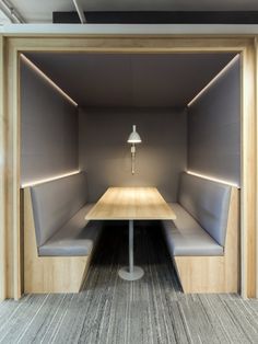 an empty booth with two benches and a lamp on the wall in front of it