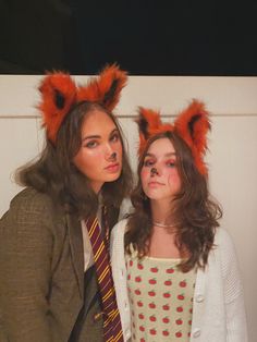 two young women dressed up as harry potter and the person with cat ears on their head