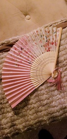 a pink fan sitting on top of a bed