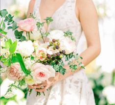 a woman holding a bouquet of flowers in her hands