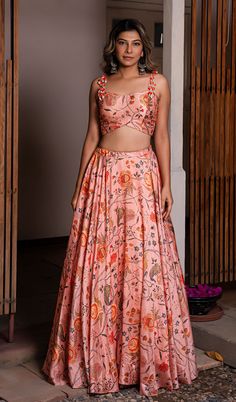 Peach raw silk printed lehenga set comes with sleeveless blouse adorned with shell and contrast thread tassels. Back closing with hook-eye opening. Color - Peach. Fabric of Lehenga + Crop Top - Printed Raw Silk. Number of components - 2. Measurements in the size chart are all garment measurements. The actual print-placement of the product may vary slightly from the image shown. Standard Lehenga Length - 43". Standard Crop Top Length - 14.5" (XS,S,M) ; 15" (L) ; 15.5" (XL) ; 16" (XXL,3XL,4XL,5XL, Pink Sleeveless Bohemian Sets, Pink Floor-length Bohemian Choli, Floor-length Pink Bohemian Choli, Pink Bohemian Floor-length Choli, Pink Bohemian Floor-length Lehenga, Bohemian Style Pink Floor-length Lehenga, Bohemian Pink Floor-length Lehenga, Summer Pink Floral Print Choli, Pink Summer Lehenga With Pallu Detail