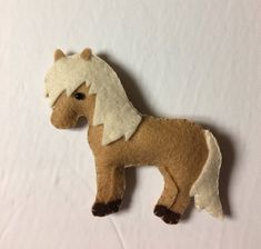 a brown and white stuffed horse sitting on top of a white table next to a wall