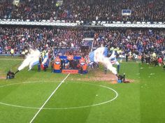 a soccer field with players on it and fans in the stands