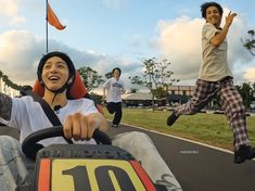 two young men riding on top of an amusement vehicle