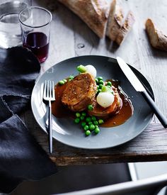 a plate that has some food on it with a fork and glass next to it