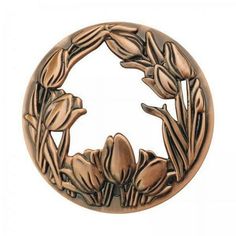 an image of a metal object with flowers in the center and leaves on it's side