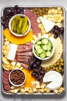 an assortment of cheeses, meats, and vegetables on a platter