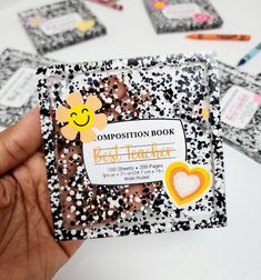 a person holding up a book with stickers on it