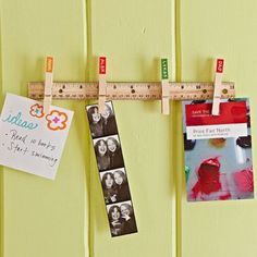 there are pictures hanging on the pegs with tape and magnets attached to them