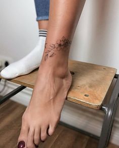 a woman's foot with a flower tattoo on her left ankle and right foot