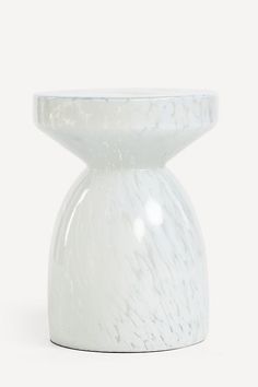 a white vase sitting on top of a table