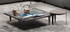 a coffee table with an open book on it and two side tables next to it