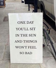 a sign that says one day you'll sit in the sun and things won't feel so bad